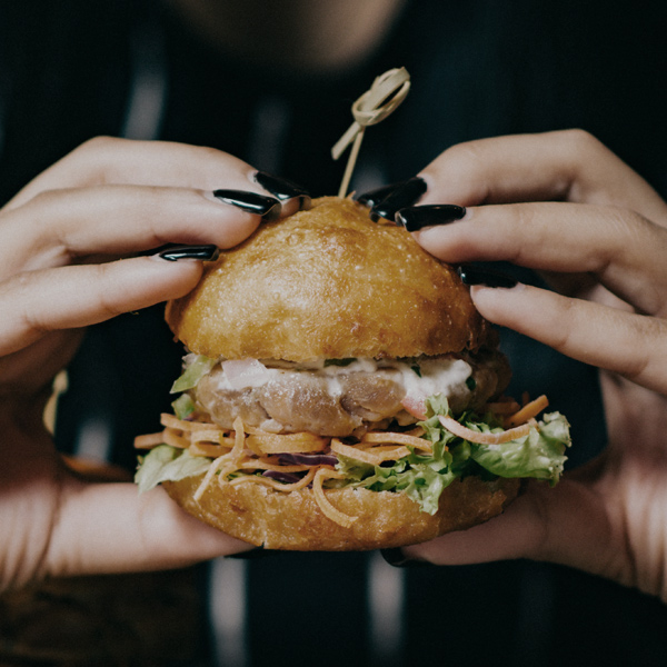 Ein Bild von zwei Händen die einen Burger halten